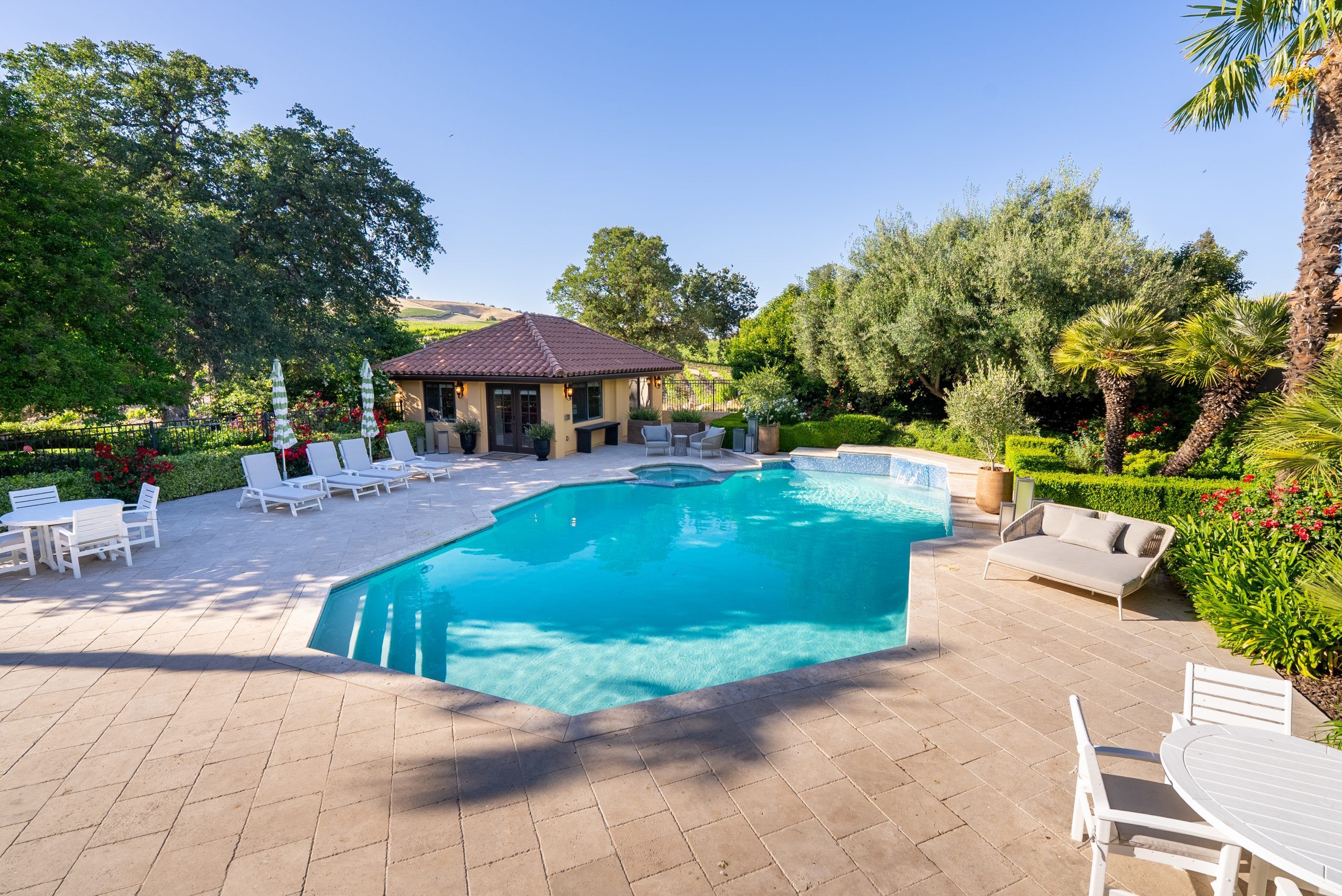 Pool and poolhouse surrounded by mature landscaping at Villa San-Juliette