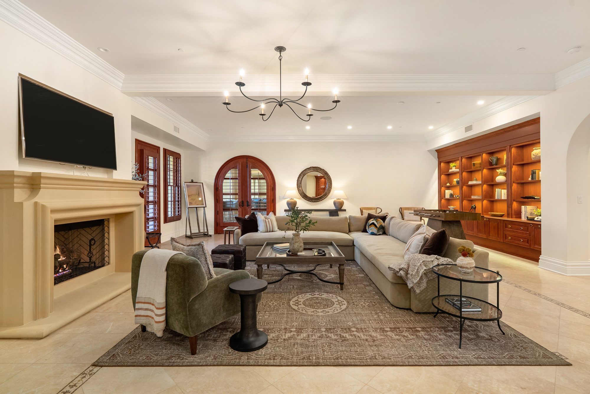 East Villa downstairs living room with fireplace and arched wood doors